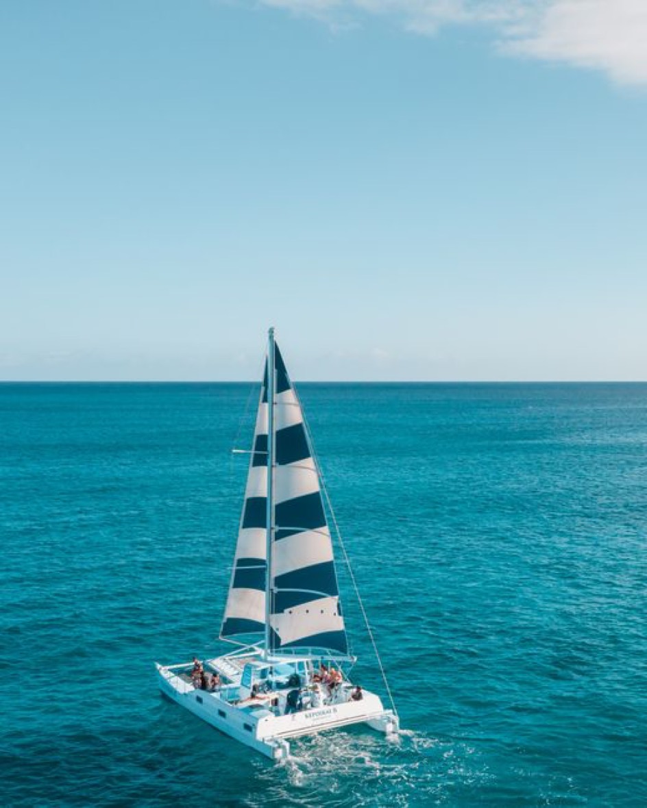 Catamaran sailing on bright turquoise water